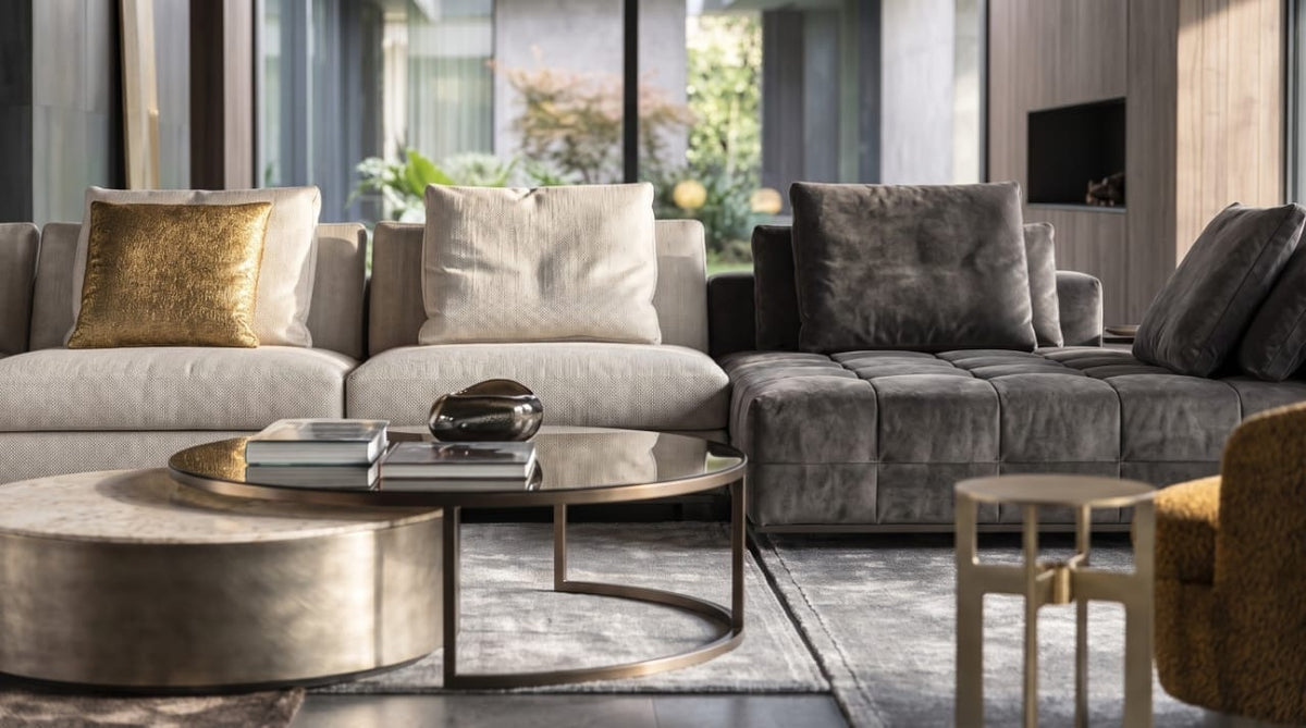 Grey and ivory modular sofa with gold cushion, round bronze coffee tables