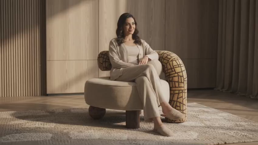 Woman relaxing in a bouclé armchair in a warm living room